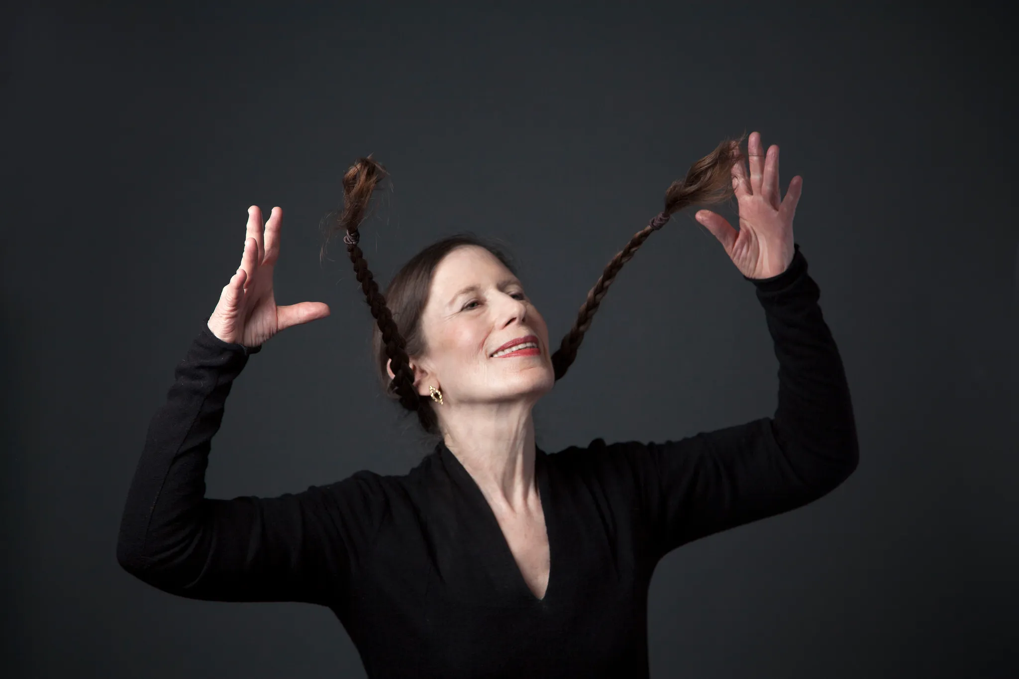 Meredith Monk die haar vlechten omhoog zwaait