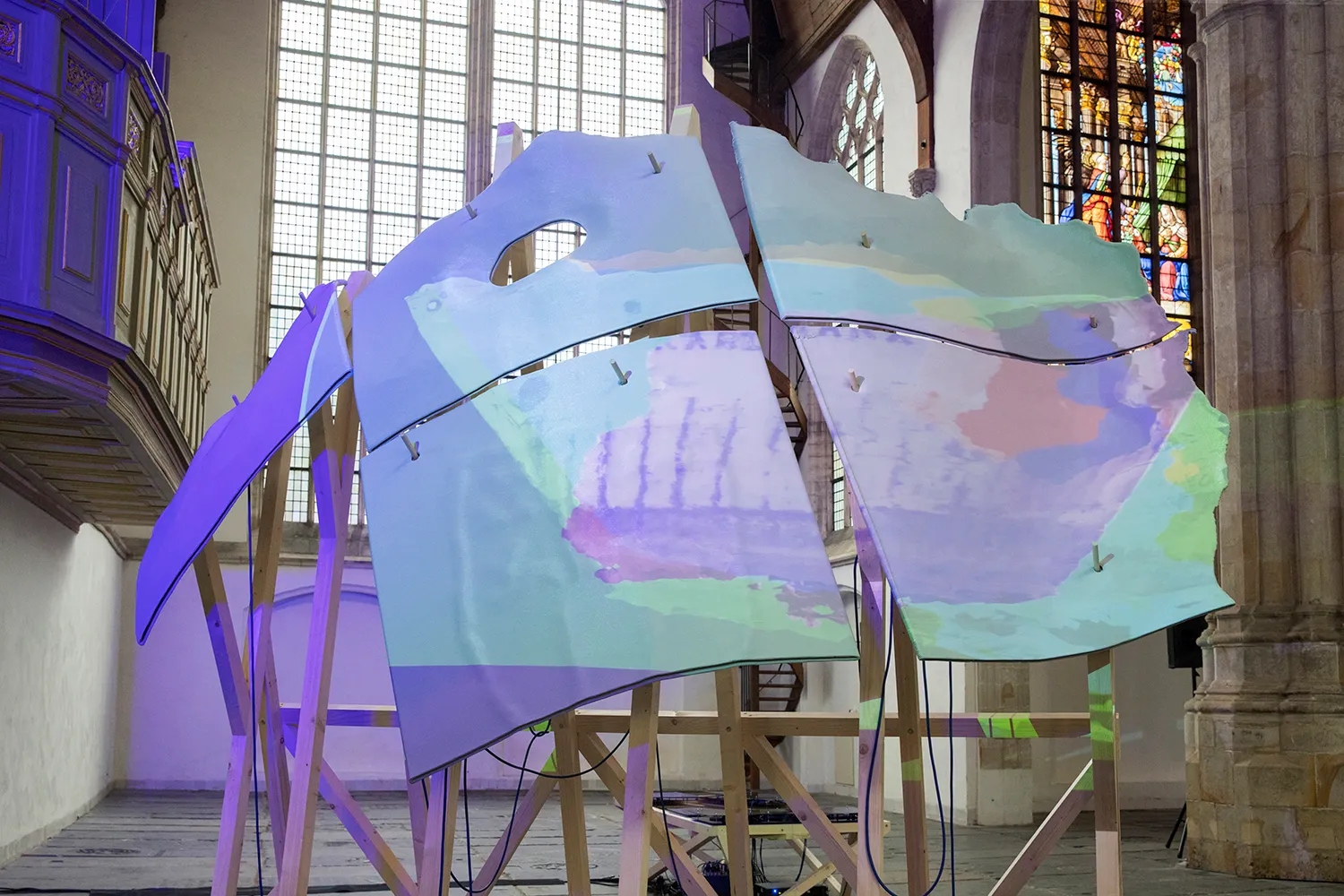 Blauw/groen/paarse projectie op een sculptuur in de Oude Kerk van Amsterdam.