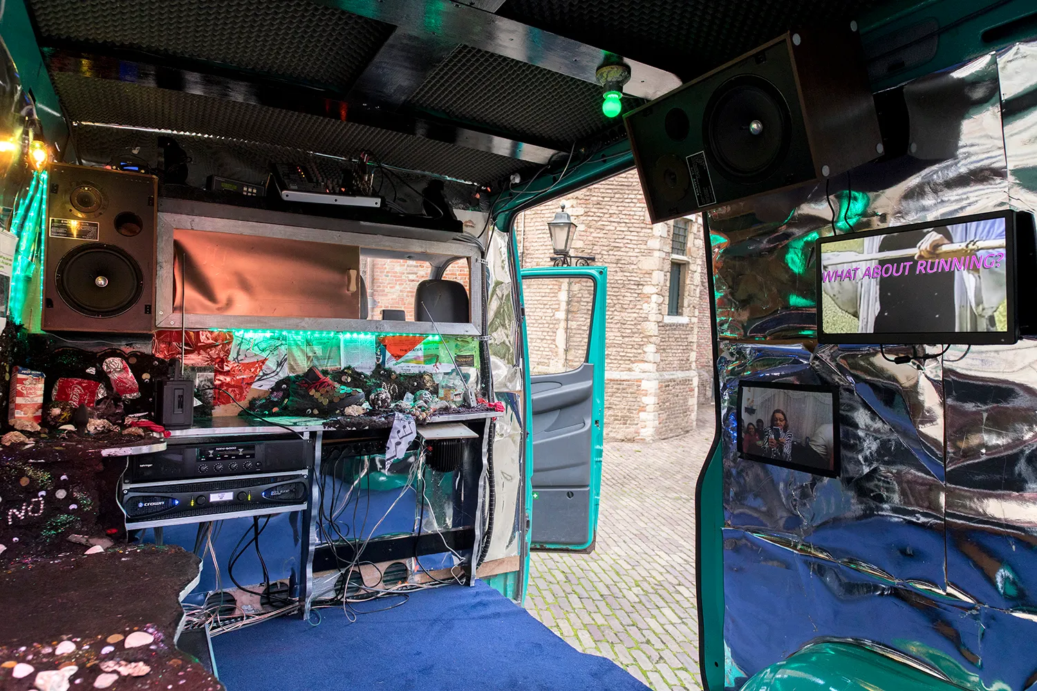 Interior of the van with a.o. screens, speakers, radio’s and blue carpet