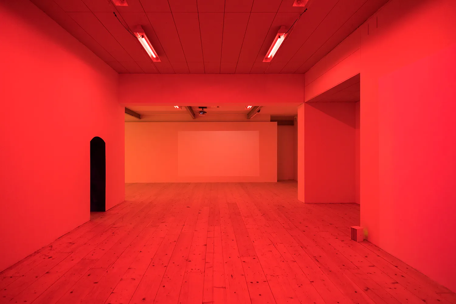 An empty gallery space with red light
