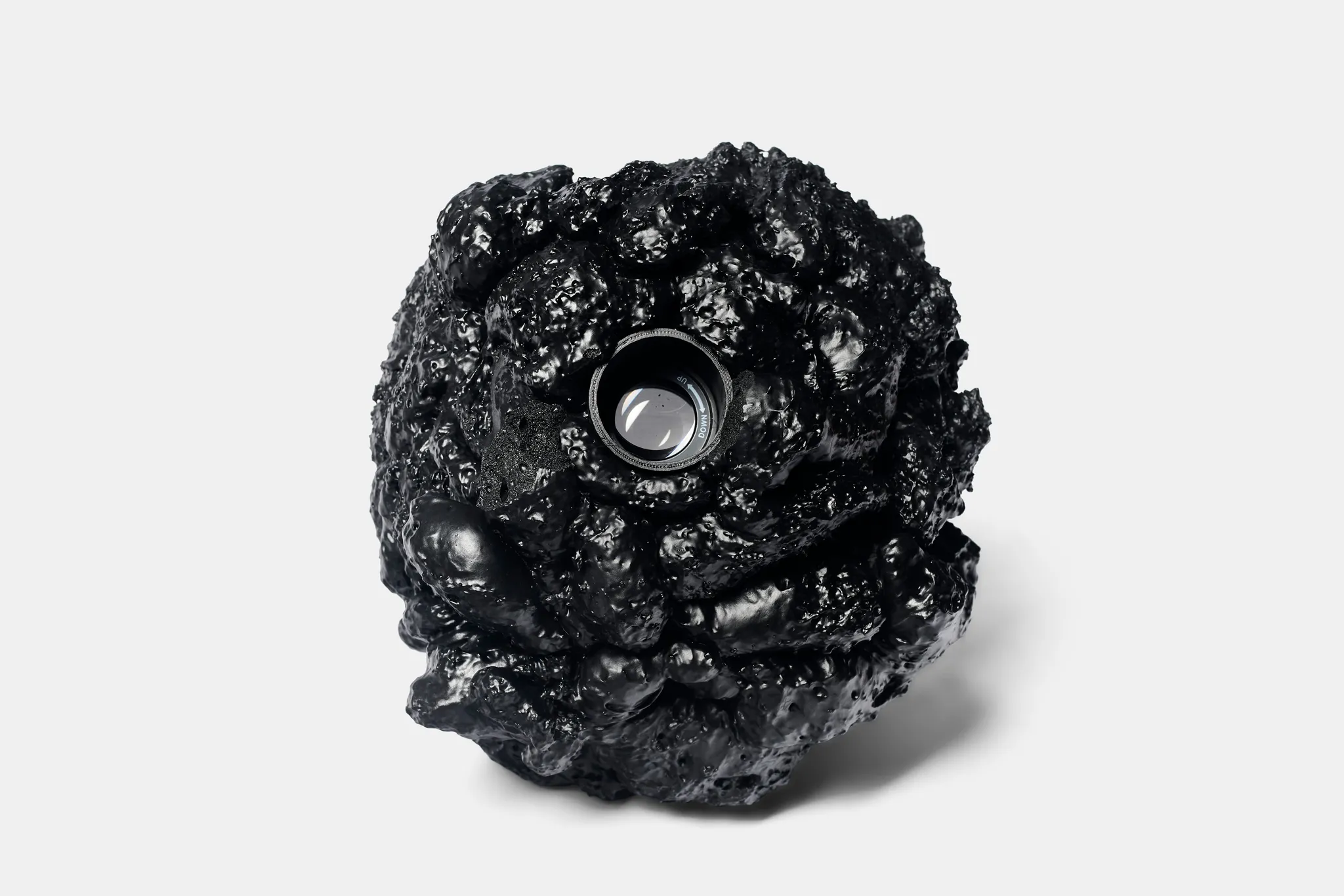 A shiny black rock with a lens inside
