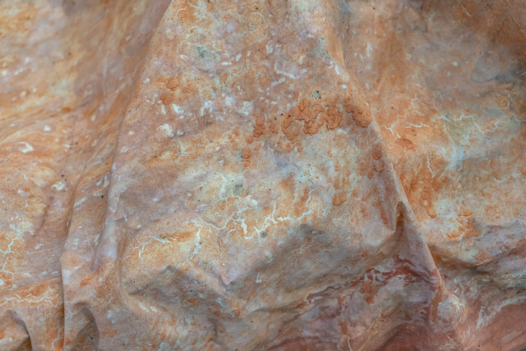 Close-up of a wobbly canvas with dried and hardened orange muddy clay.